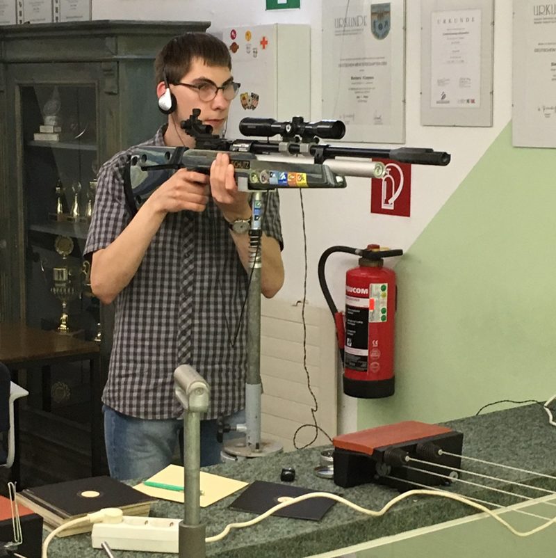 Junger Mann hält ein Luftgewehr