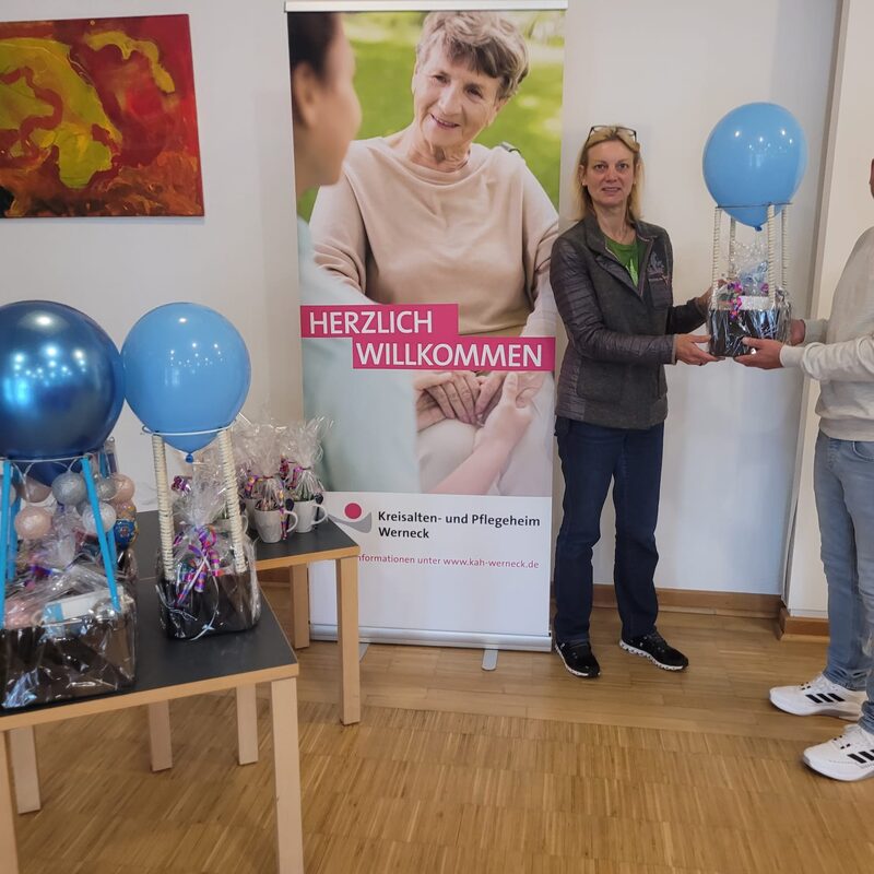 Teilnahme an der Tombola in einem Pflegeheim in Werneck. Der Geschäftsführer Mark überreicht unsere Spende für die Tombola an die Einrchtungsleitung