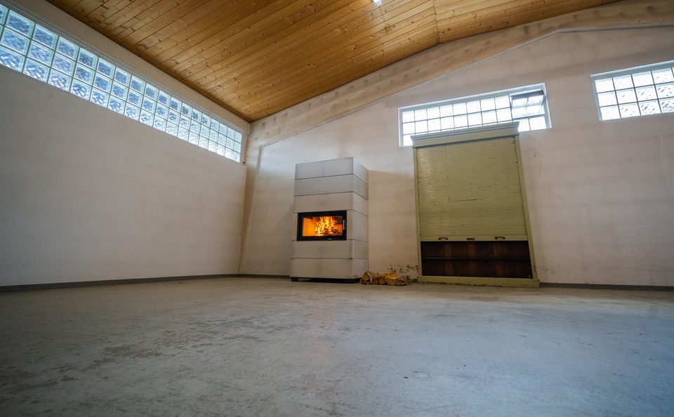 Ein Ofen in Betonoptik neben einen großen alten Schrank